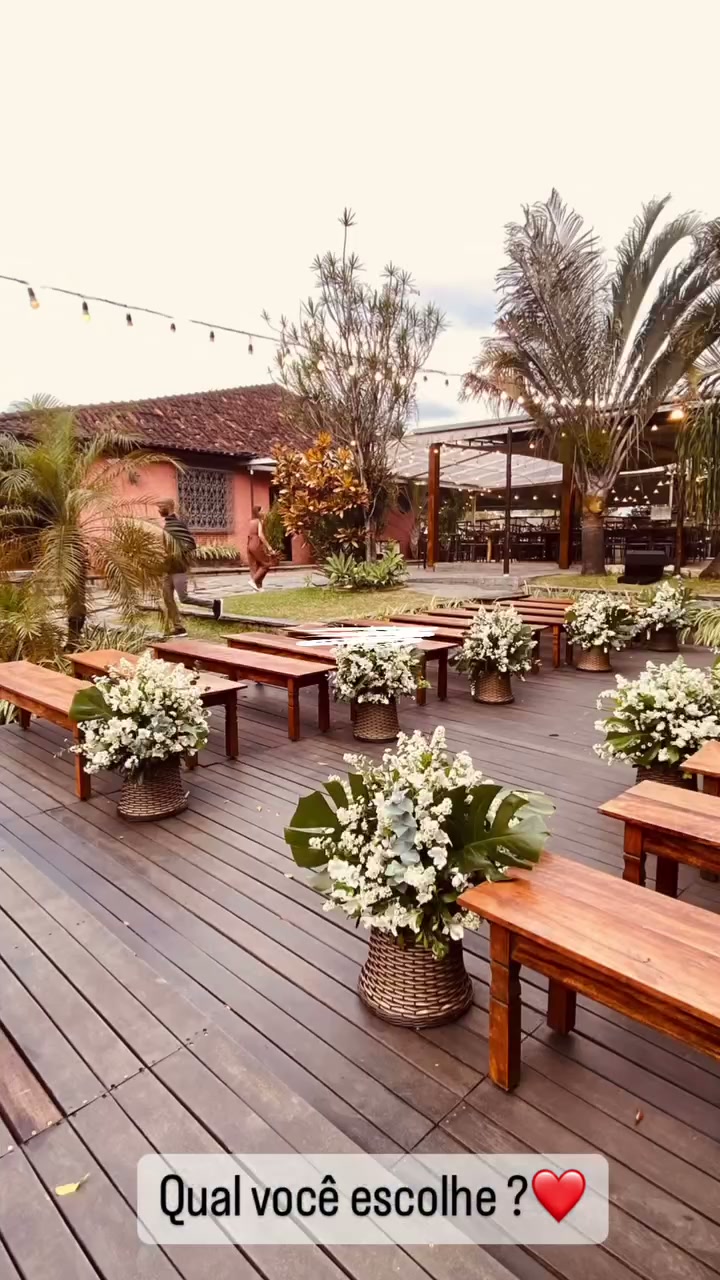Deck de madeira com bancos e altar de flores cercado de verde
